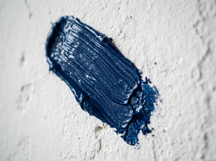 Close-up of a fresh navy blue brushstroke, showing paint finish quality